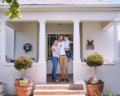 A family standing in front of a house | Featured image for the Home Page for Spectrum Estate Agents - Brisbane Real Estate Agency.